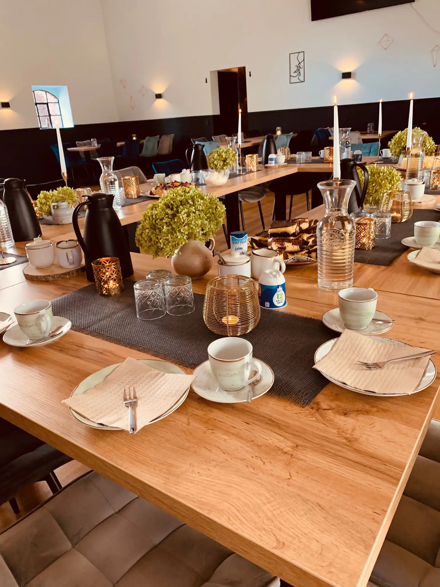 Kaffeegedeck mit Hortensien und Kerzen auf der Holztafel